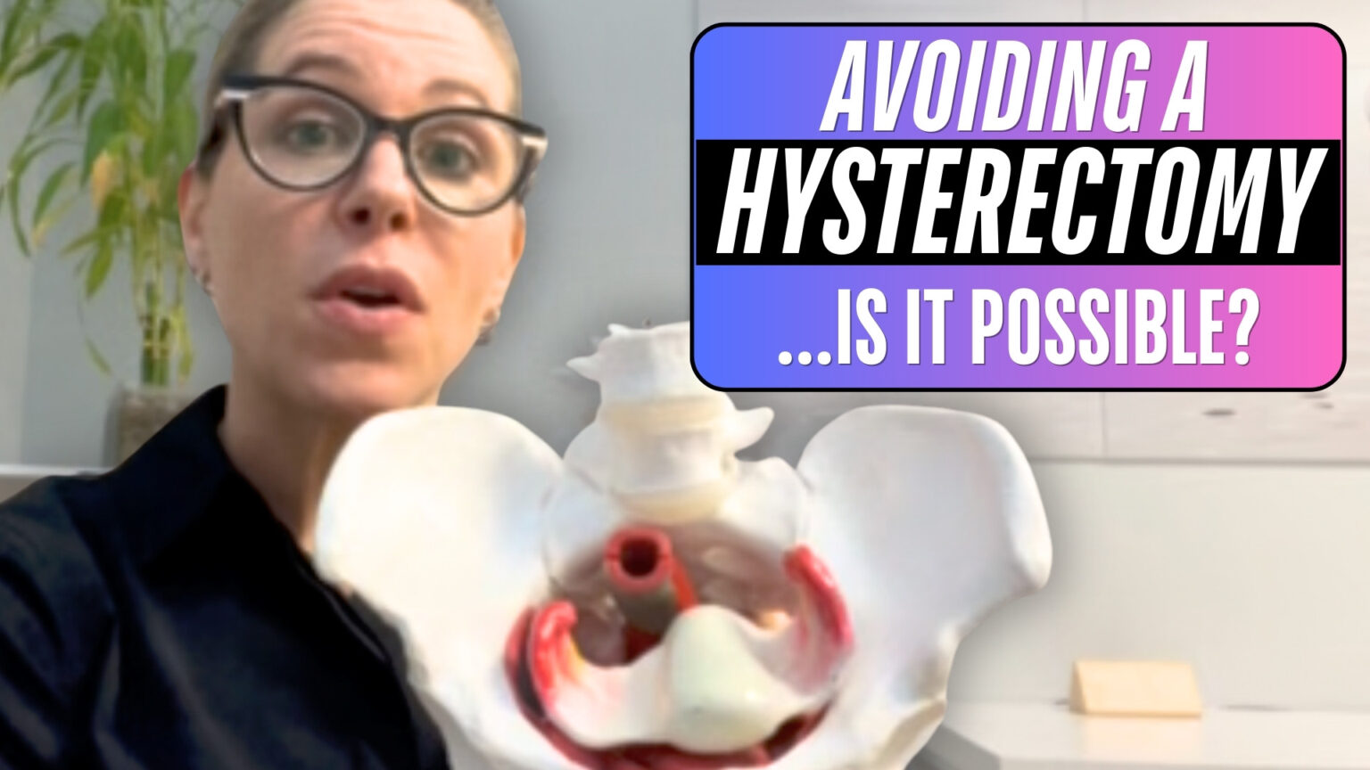 A person in a dark top holds a model of a pelvis with visible internal structures, including a uterus and red-colored arteries, on a white surface. In the background, there is a green plant and a small beige object. A colorful text overlay reads, "AVOIDING A HYSTERECTOMY ...IS IT POSSIBLE?" with a gradient background.